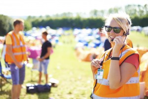 Young rescue assistant at a music festival speaking on the phone